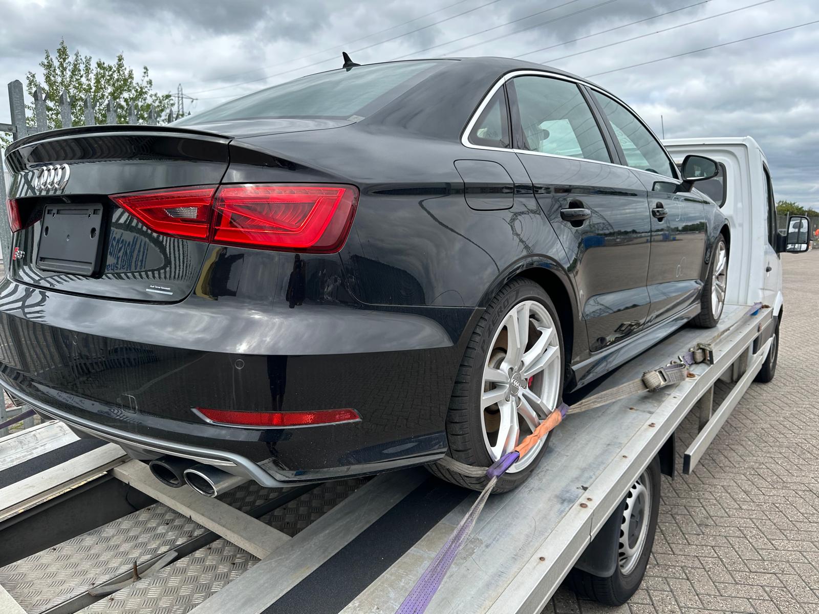 a black car collected from auction site on a recovery truck